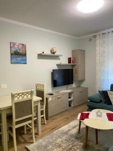 een woonkamer met een bank, een tafel en een tv bij Apartment Shkoder in Shkodër
