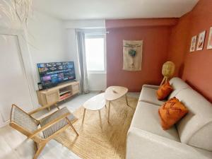 a living room with a couch and a tv at Le Mexico - hyper centre & parking in Montaigu-Vendée
