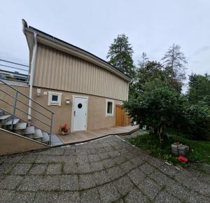 a house with a staircase leading up to a garage at R apartment in Kungsängen in Kungsängen