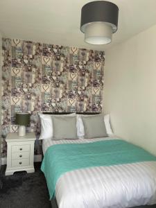 um quarto com duas camas e uma parede com corações em Oyster Retreat em Amble