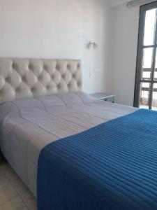 - une chambre avec un grand lit et une couverture bleue dans l'établissement Comfy en Barrio Norte, à San Miguel de Tucumán