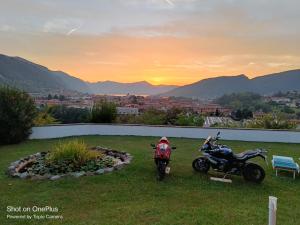 two motorcycles parked in a field with the sunset in the background at B&B La Fenice sul Lago in Villongo SantʼAlessandro