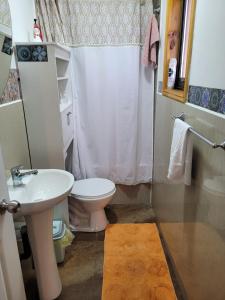 a bathroom with a white toilet and a sink at Cabañas ali in Puerto Aisén