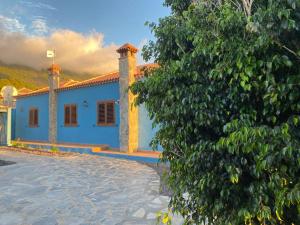 uma casa azul com uma árvore em frente em Mirador Azul em El Paso