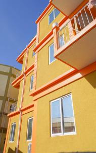 a yellow and orange building with a balcony at RJ Residences in Roseau
