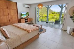 a bedroom with a large bed and a balcony at 7 bedrooms Villa, Nestled in the heights of Anse Marcel, one of the most discreet bays of the island. in Saint Martin
