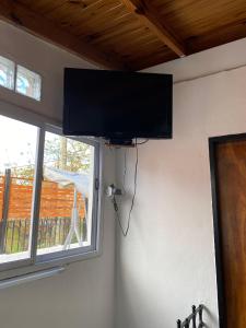 una TV a schermo piatto appesa a un muro accanto a una finestra di La casita de Greis a La Unión