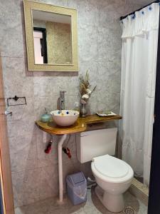 a bathroom with a toilet and a sink and a mirror at La casita de Greis in La Unión