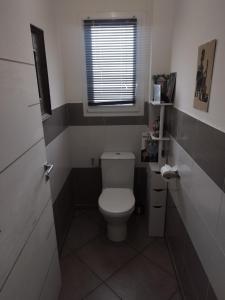 a small bathroom with a toilet and a window at Chambre chez l'habitant, lit 160x200 in Ustaritz