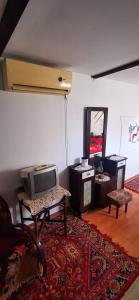 een woonkamer met een tv op een tafel bij Etno domaćinstvo Miris Bosiljka in Mislođin