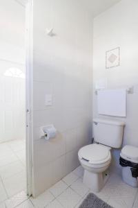 y baño blanco con aseo y ducha. en Habitación Privada en Zona Dorada en Mazatlán