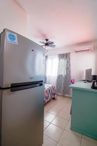 uma cozinha com um frigorífico num quarto com uma cama em Habitación Privada en Zona Dorada em Mazatlán