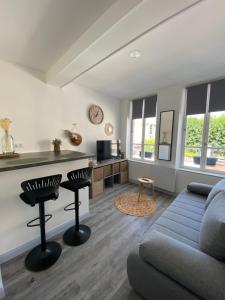 a living room with a couch and a table at L'Emile Zola in Saint-Quentin