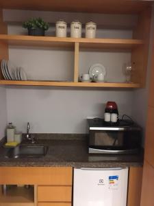 cocina con fregadero y microondas en Flat com 02 suítes no Jardins, en São Paulo