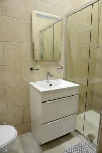 La salle de bains blanche est pourvue d'un lavabo et d'une douche. dans l'établissement The Cosy Corner studio, à Sheffield