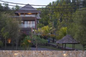 ein Haus inmitten eines Gartens mit Bäumen in der Unterkunft Villa Mandalika Lombok in Kuta Lombok