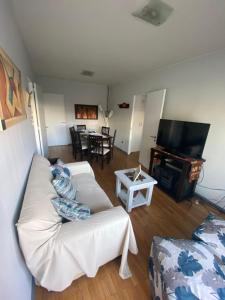 a living room with a white couch and a television at DEPTO PEDRO MOLINA in Mendoza