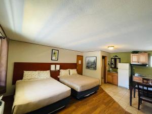 a hotel room with two beds and a kitchen at Hunter's Friend Resort Near Table Rock Lake in Branson