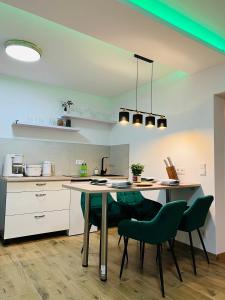 a kitchen with a table and green chairs at Ferienhaus Doina in Gehlberg