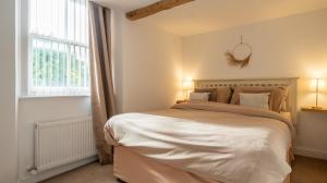 Un dormitorio con una cama grande y una ventana en Wee Toad Hole Heart of Kendal - Cottage sleeps 4-6 - Dogs Welcome, en Kendal