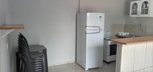 a kitchen with a white refrigerator and a table at Alter do Chão Casa 02 in Alter do Chao