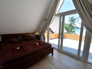 a bedroom with a bed with a view of the ocean at Dragon Sea View Villa in Ko Chang