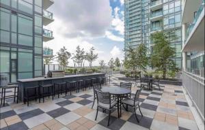 a patio with tables and chairs on a building at Ultra Luxurious 2.5 Bedroom 2 Full Bathroom 1 Parking Condo Near SQ1 Striking Views in Mississauga