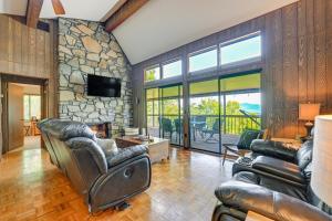 a living room with leather furniture and a stone wall at Stunning Franklin Cabin with Deck and Mountain Views in Franklin