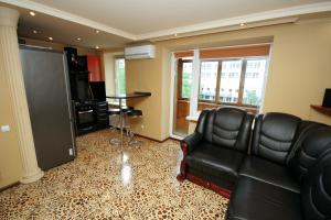 a living room with a black leather couch and a television at Pechersk Apartment in Kiev Center in Kyiv