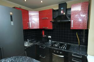 a kitchen with red cabinets and a sink at Pechersk Apartment in Kiev Center in Kyiv