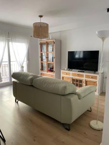 sala de estar con sofá y TV de pantalla plana en Exclusivo apartamento cerca de la playa, en Málaga
