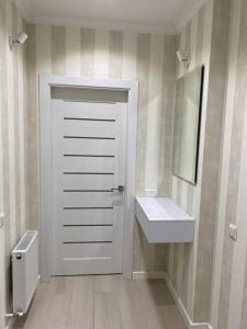 a bathroom with a white door and a sink at Zoe’s cozy apartment in Chişinău