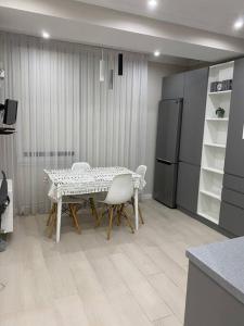 a kitchen with a table and chairs and a refrigerator at Zoe’s cozy apartment in Chişinău