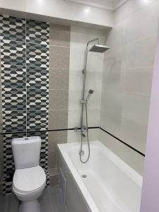 a bathroom with a toilet and a bath tub at Zoe’s cozy apartment in Chişinău