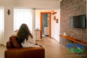 a woman sitting on a couch in a living room at Atlântida Dream T1 in Angra do Heroísmo