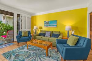 a living room with two blue couches and a coffee table at Kiahuna Paradise at Poipu beach, newly remodeled in Koloa