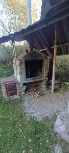 an outdoor oven is sitting under a tent at Domek pod lasem in Maniowy
