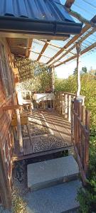 a wooden deck with a bench under a roof at Domek pod lasem in Maniowy