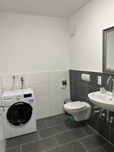 uma casa de banho com uma máquina de lavar roupa e um lavatório em Othman Appartements Alte Schmiede 22 em Hanôver