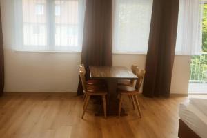 a dining room with a table and two chairs at Othman Appartements Alte Schmiede 22 in Hannover +7 photos