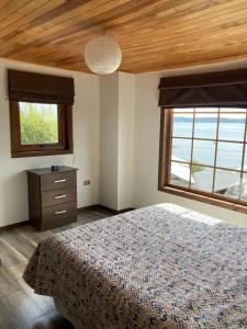 1 dormitorio con 1 cama, vestidor y 2 ventanas en Habitación privada, vista al mar 1 en Ancud