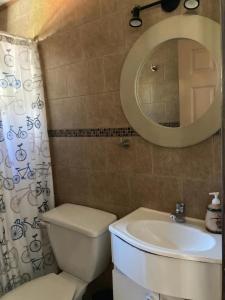bagno con lavandino, servizi igienici e specchio di Habitación privada, vista al mar 1 ad Ancud