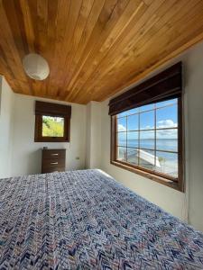 1 dormitorio con cama y ventana grande en Habitación privada, vista al mar 1, en Ancud