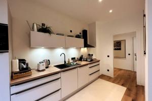 a kitchen with white cabinets and a counter top at 4YOUnic: *2BR*55“TV*Balkon*Parkplatz in Leipzig