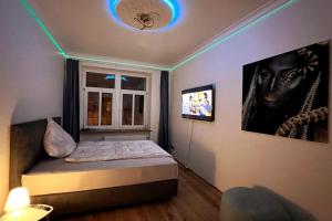 um quarto com uma cama e uma televisão no tecto em 4YOUnic: *2BR*55“TV*Balkon*Parkplatz em Leipzig
