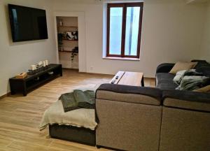 a living room with a couch and a table at Maison au cœur du Revermont in Ménétru-le-Vignoble