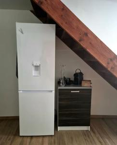 a white refrigerator in a room with a wooden ceiling at Maison au cœur du Revermont in Ménétru-le-Vignoble