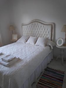 Una cama blanca con sábanas blancas y almohadas. en Cabañas Boutique San Lorenzo en San Lorenzo