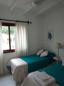 1 dormitorio con 2 camas y ventana en Cabañas Boutique San Lorenzo en San Lorenzo