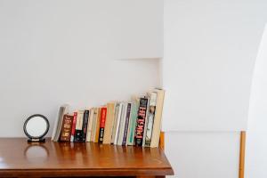 eine Reihe von Büchern auf einem Regal mit einem Spiegel in der Unterkunft Trullo Rosy in Martina Franca